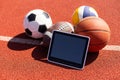 balls and tablet computer on color background. Concept of sports bet