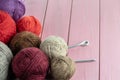 Balls of yarn in different colors with knitting needles on a background of pink wood texture. Royalty Free Stock Photo