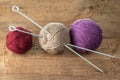 Balls of yarn in different colors with knitting needles on a background of rough wood Royalty Free Stock Photo