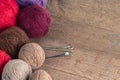Balls of yarn in different colors with knitting needles on a background of rough wood texture. Royalty Free Stock Photo