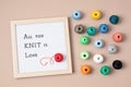 Balls of yarn and letter board with text All you knit is love. Royalty Free Stock Photo