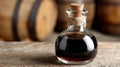 Balsamic vinegar bottle on rustic wooden table with barrels. Royalty Free Stock Photo