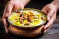 balti dish of indian kheer rice pudding being served by a hand