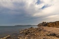 Baltic Sea beach with cliffs the stones on the beach and a sky full of clouds Royalty Free Stock Photo