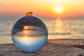 Baltic Sea beach in the glass sphere in the backlight with illuminated amber in the sunset