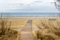 Baltic sea beach with wooden footpath and sand.