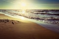 Baltic sea coast with waves breaking on the beach at sunset. Scenic picturesque summer seascape.