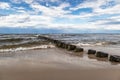 Baltic sea shore with breakwaters and blue sky with clouds Royalty Free Stock Photo