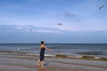 Baltic sea, woman walking along the beach and feeding white gu Royalty Free Stock Photo