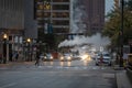 Baltimore Downtown with Traffic in Background. People Crossing Street. Pipe Vapour Steam in Background