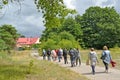 BALTIYSK, RUSSIA. A group of tourists walks along the path to the turbine building. Baltic Spit, Kaliningrad Region Royalty Free Stock Photo