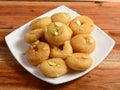 Balushahi an Indian Traditional Sweet Food served over a white plate on a rustic wooden background, selective focus Royalty Free Stock Photo