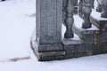 Balustrade of the rotunda under the snow. Gray granite exterior details during a snowfall. Fragment of a city landmark