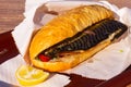 Balyk kebab, fresh fishfishburger, fish sandwich lying in the unfolded paper packaging. Sunny day.