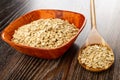 Bamboo bowl with oat flakes, spoon with oatmeal on wooden table