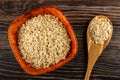 Bowl with raw oat flakes, spoon with oatmeal on wooden table. Top view