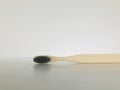 Charcoal infused bamboo toothbrush on marble white background. Horizontal.