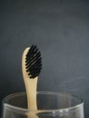 Charcoal infused bamboo toothbrush on grey black background. Copy space.