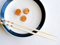 Bamboo chopsticks, plate, and pennies Royalty Free Stock Photo