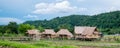 The bamboo cottage, the simple lifestyle of a Thai farmer with a mountainous background below the blue sky at Thailand Royalty Free Stock Photo