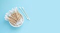 Bamboo cotton swabs or sticks top view on blue background