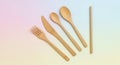 Bamboo cutlery set displayed on a pastel-colored background. The set includes a fork, serrated Royalty Free Stock Photo