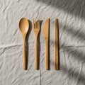 Bamboo cutlery set on a textured, light-colored fabric. The set includes a spoon, fork, Royalty Free Stock Photo