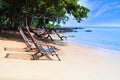 Bamboo deck chairs on the sandy beach with bright sun and waves, Island south of THAILAND. Relaxing day at the beach Royalty Free Stock Photo