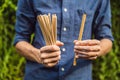 Bamboo drinking straw vs disposable straws in hands. Zero waste concept