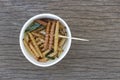 Bamboo edible worm insects crispy or Bamboo Caterpillar in white paper cup on wood table. The concept of protein food sources from Royalty Free Stock Photo