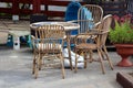 Bamboo garden furniture in shape of small table and three outdoor chairs surrounded with flowers in flower pot and children toys Royalty Free Stock Photo