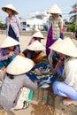 Bamboo hat Vietnamese women choose fish to sell in market