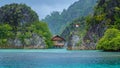 Bamboo Hut between some Rocks under Rain in Bay with Indonesian Flag, Pianemo Islands, Raja Ampat, West Papua, Indonesia Royalty Free Stock Photo