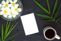 Bamboo leaf and frangipani flower on rustic wooden background. Blank card and floral decor top view. Royalty Free Stock Photo