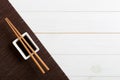 Bamboo mat and soy sauce with sushi chopsticks on white wooden table. Top view with copy space background for sushi. Flat lay Royalty Free Stock Photo