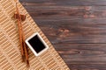 Bamboo mat and soy sauce with sushi chopsticks on wooden table. Top view with copy space background for sushi. Flat lay Royalty Free Stock Photo