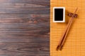 Bamboo mat and soy sauce with sushi chopsticks on wooden table. Top view with copy space background for sushi. Flat lay Royalty Free Stock Photo