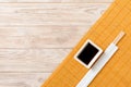 Bamboo mat and soy sauce with sushi chopsticks on wooden table. Top view with copy space background for sushi. Flat lay Royalty Free Stock Photo