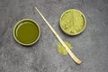 Bamboo measuring spoon on the table. Green matcha tea powder and matcha tea in green bowls Royalty Free Stock Photo