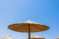 Bamboo parasols beach umbrellas with clear blue sky background on summer day Royalty Free Stock Photo