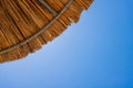 Bamboo parasols beach umbrellas with clear blue sky background on summer day Royalty Free Stock Photo