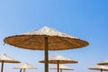 Bamboo parasols beach umbrellas with clear blue sky background on summer day Royalty Free Stock Photo