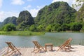 Bamboo terrace chairs view lake karst mountains, Ninh Binh, Vietnam