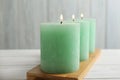 Bamboo plate with three burning candles Royalty Free Stock Photo