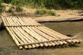 Bamboo raft and worn timber log on a river bank