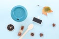 Bamboo reusable takeaway cup with lid on with autumn leaf, wooden spoon and other objects, flat lay on blue background Royalty Free Stock Photo