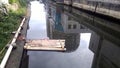 A bamboo row in the river and the surrounding buildings reflected in the water. Royalty Free Stock Photo