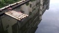 A bamboo row in the river and the surrounding buildings reflected in the water. Royalty Free Stock Photo