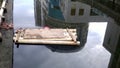 A bamboo row in the river and the surrounding buildings reflected in the water. Royalty Free Stock Photo