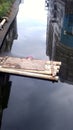 A bamboo row in the river and the surrounding buildings reflected in the water. Royalty Free Stock Photo